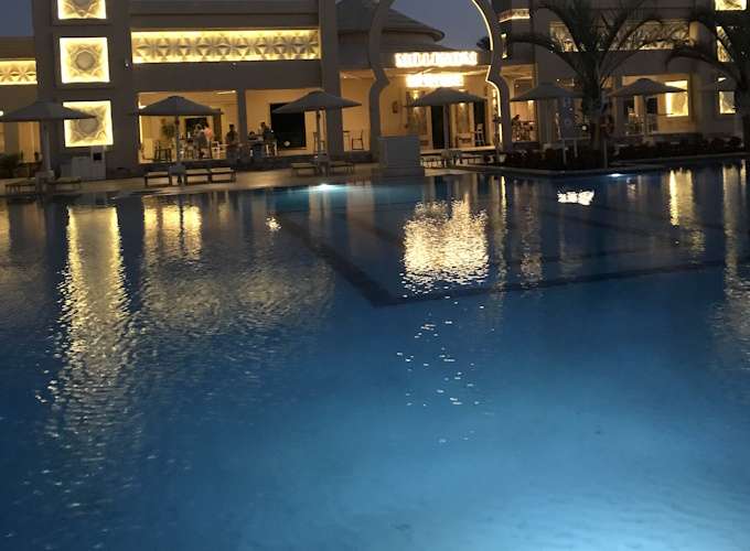 Blick über den Pool Richtung Restaurants am Abend